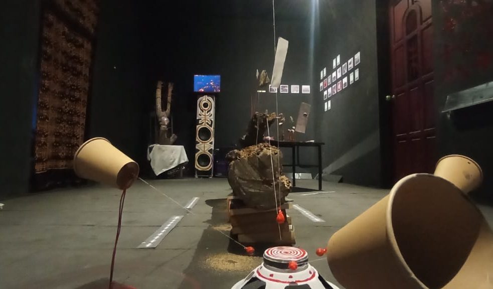 Suasana ruang pamer SISA di Rumah Tiara Coffee, Palu. Instalasi heterogen berupa benda-benda sisa, tali, tanah, dan wadah kosong disusun di ruang gelap, menciptakan lanskap simbolik tentang hubungan manusia, lingkungan, dan ruang hidup yang terus mengalami pergeseran.